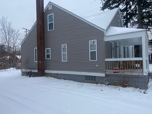 view of snowy exterior featuring a porch