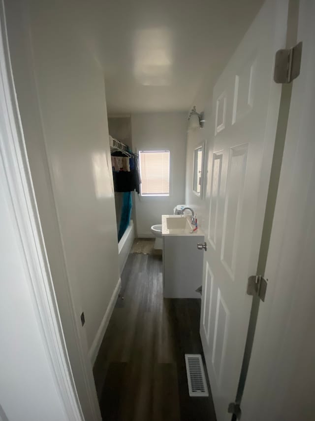 full bathroom with hardwood / wood-style flooring, vanity, shower / bath combo with shower curtain, and toilet