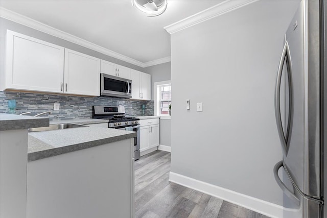 kitchen with white cabinetry, decorative backsplash, sink, light hardwood / wood-style flooring, and stainless steel appliances