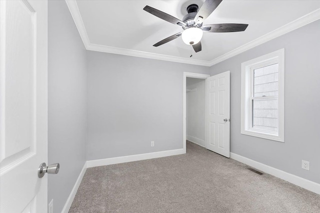 unfurnished bedroom with ceiling fan, crown molding, and light carpet