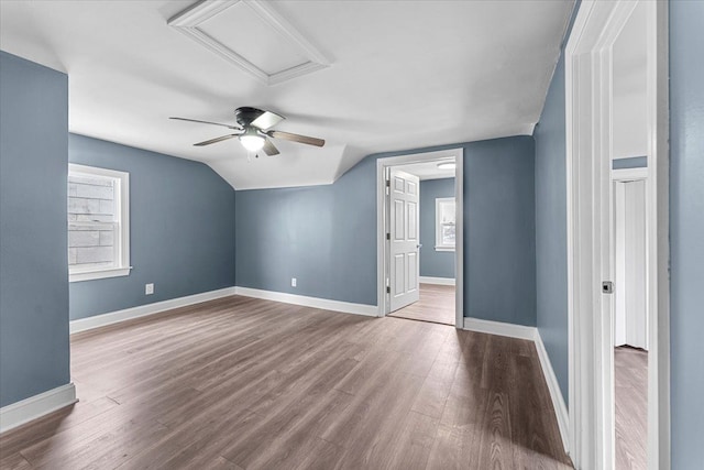 additional living space with hardwood / wood-style floors and lofted ceiling