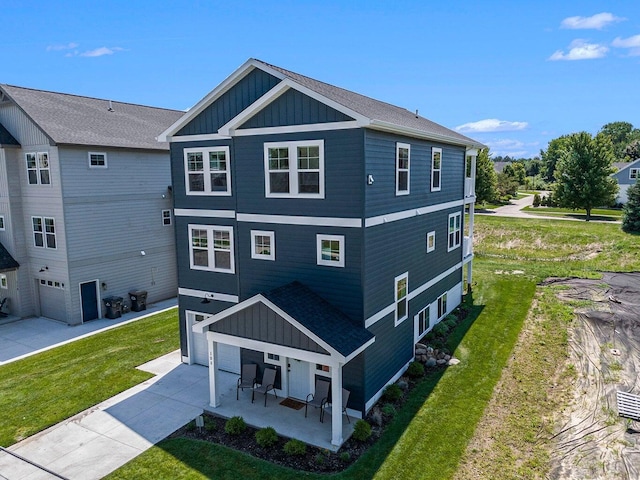 rear view of property with a garage and a lawn