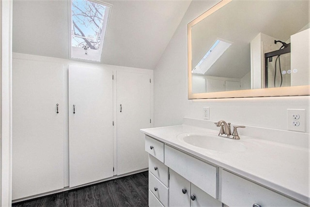 bathroom featuring hardwood / wood-style floors, vaulted ceiling, and vanity