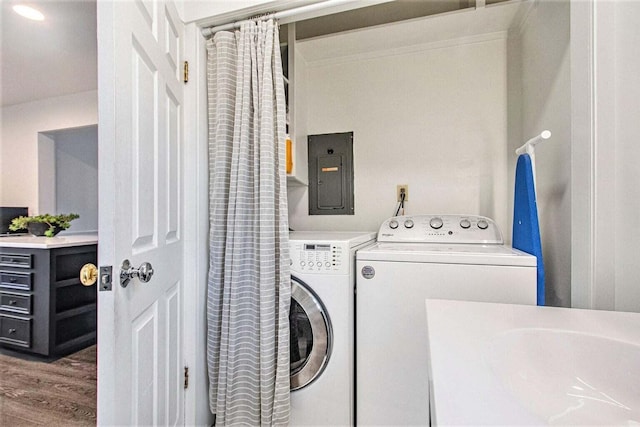 washroom featuring washing machine and dryer, electric panel, dark hardwood / wood-style flooring, and sink