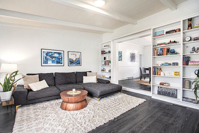 living room with dark wood-type flooring and beamed ceiling