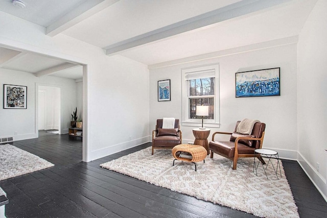 sitting room featuring beam ceiling and dark hardwood / wood-style floors