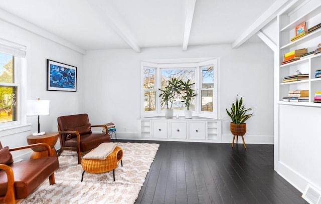 sitting room with dark hardwood / wood-style flooring, beamed ceiling, and a healthy amount of sunlight