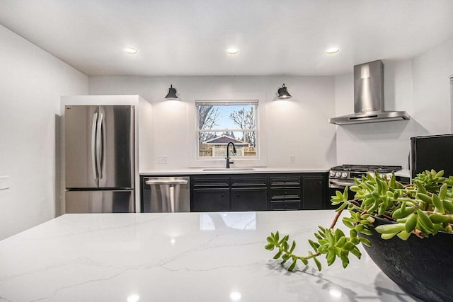 kitchen with sink, stainless steel appliances, light stone counters, and wall chimney exhaust hood