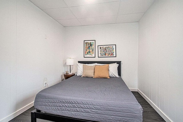 bedroom with dark wood-type flooring and a drop ceiling