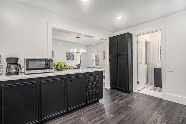 kitchen with decorative light fixtures, an inviting chandelier, and dark hardwood / wood-style flooring