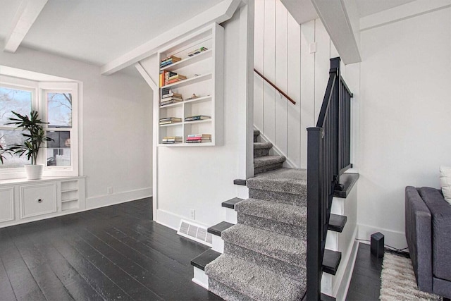 stairway featuring built in shelves, hardwood / wood-style flooring, and beam ceiling