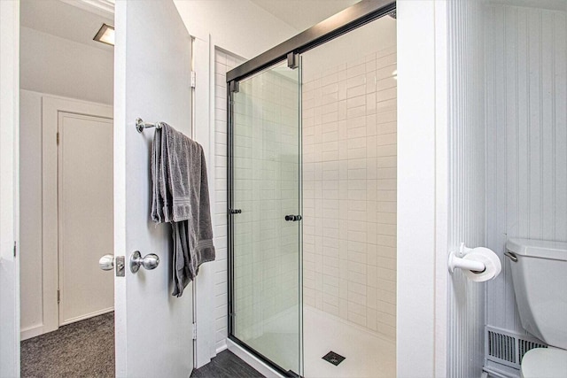 bathroom featuring toilet and an enclosed shower