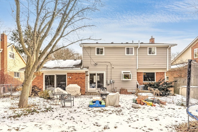 view of snow covered back of property