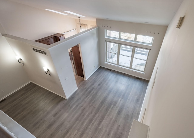 unfurnished room featuring hardwood / wood-style floors and a towering ceiling