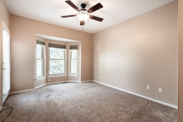 carpeted spare room with ceiling fan