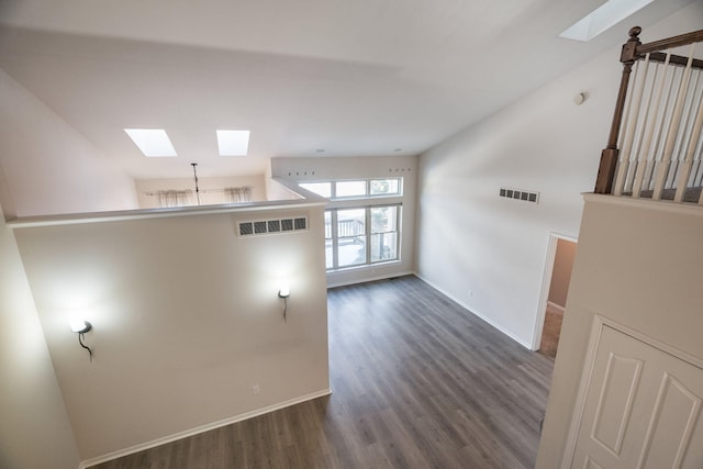 interior space with a skylight and dark hardwood / wood-style flooring