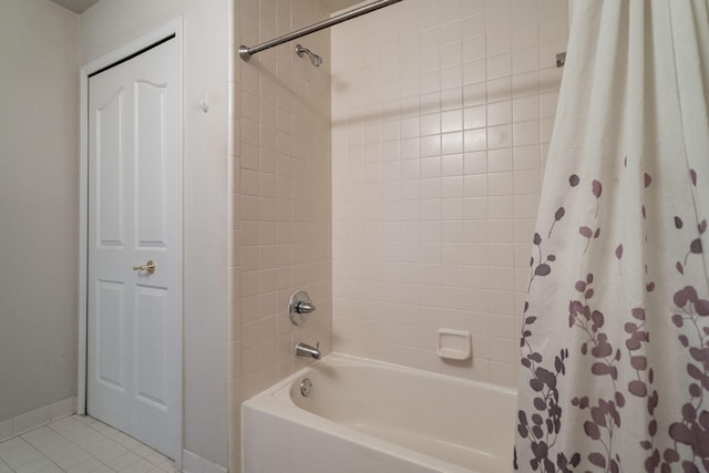 bathroom with shower / bath combo with shower curtain and tile patterned flooring