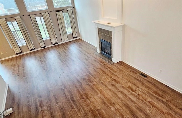 unfurnished living room with hardwood / wood-style floors and a tile fireplace