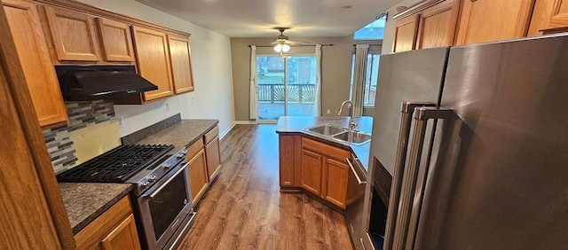 kitchen with sink, ceiling fan, stainless steel appliances, wood-type flooring, and decorative backsplash