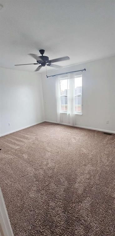 empty room with ceiling fan and carpet flooring