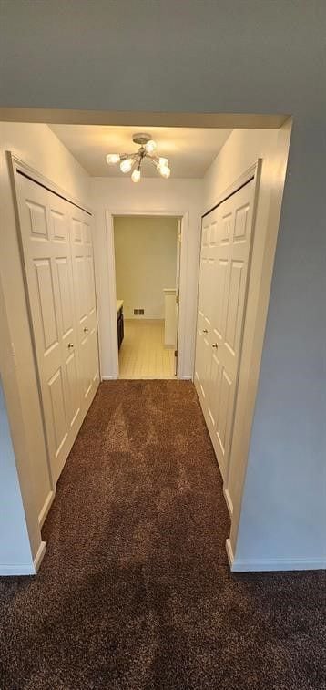 hallway featuring dark colored carpet