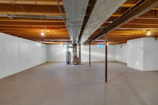 basement featuring gas water heater and heating unit