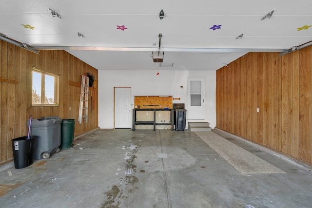 garage with a garage door opener and wood walls