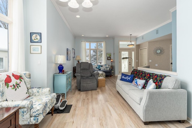 living room with crown molding and light hardwood / wood-style flooring