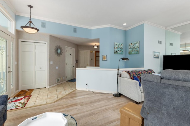 living room with crown molding and light wood-type flooring