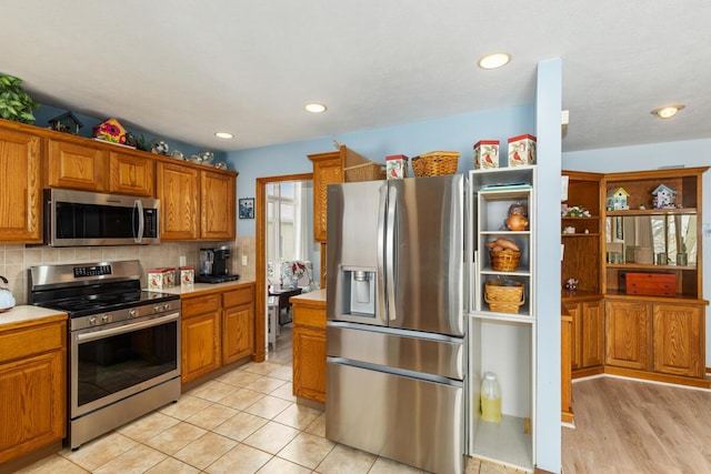 kitchen with decorative backsplash, stainless steel appliances, and light tile patterned flooring