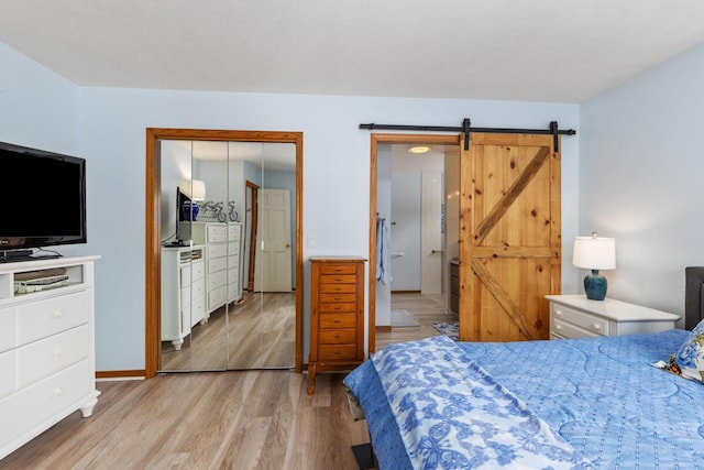 bedroom featuring light hardwood / wood-style flooring, a closet, and a barn door