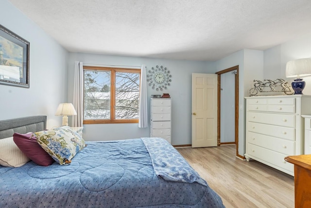 bedroom featuring light hardwood / wood-style floors and a textured ceiling