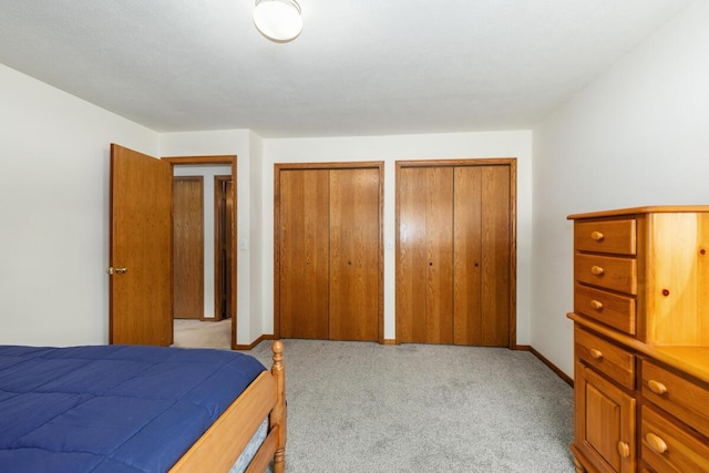 carpeted bedroom featuring two closets