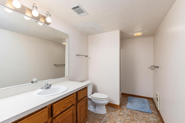 bathroom featuring a textured ceiling, toilet, and vanity