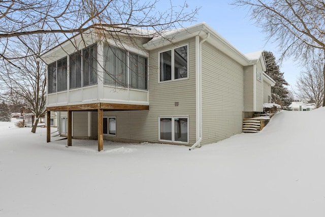 snow covered property with a sunroom