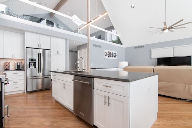 kitchen featuring sink, ceiling fan, appliances with stainless steel finishes, white cabinetry, and an island with sink