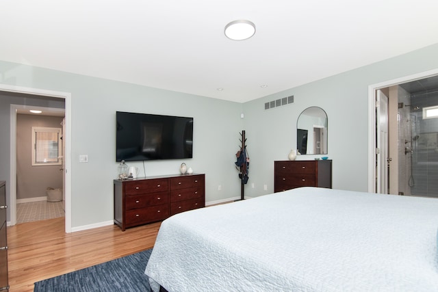 bedroom with wood-type flooring and connected bathroom