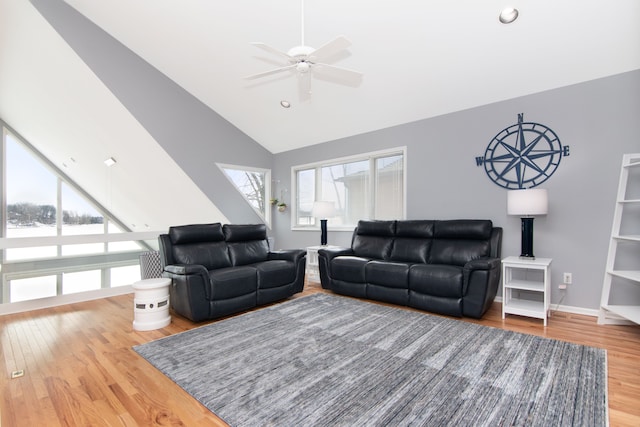 living room featuring hardwood / wood-style flooring, vaulted ceiling, and ceiling fan