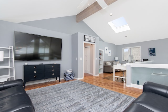 living room with hardwood / wood-style flooring and vaulted ceiling with skylight