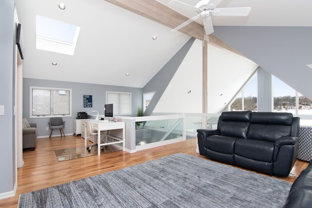 living room with lofted ceiling with skylight, hardwood / wood-style floors, and ceiling fan