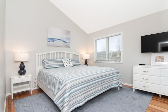 bedroom featuring lofted ceiling and hardwood / wood-style floors