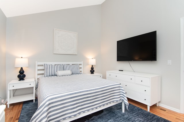 bedroom with hardwood / wood-style flooring and vaulted ceiling