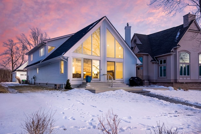 snow covered house featuring central air condition unit