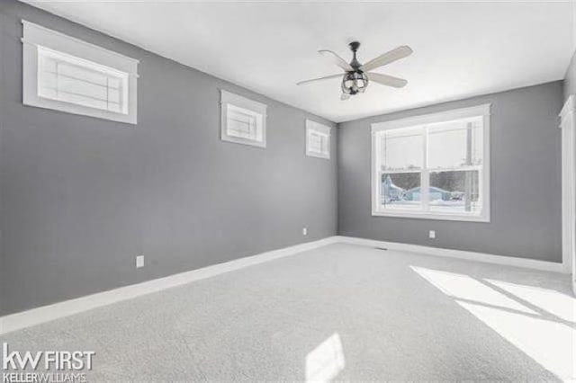 spare room with a healthy amount of sunlight, carpet floors, and ceiling fan