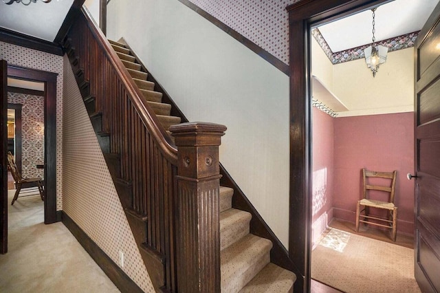 staircase featuring carpet