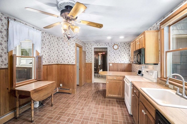 kitchen featuring black appliances, wooden walls, a baseboard radiator, and sink