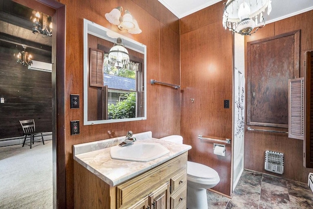 bathroom with vanity, an inviting chandelier, wooden walls, toilet, and heating unit