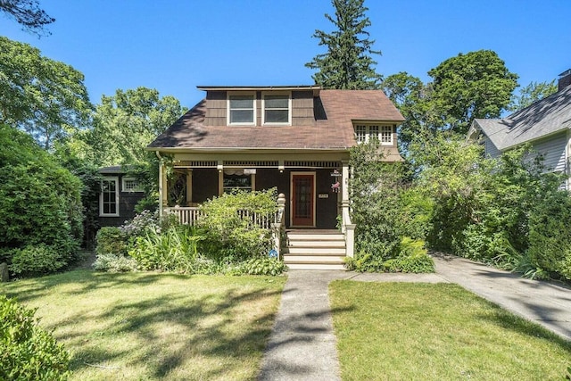 view of front of property featuring covered porch and a front yard