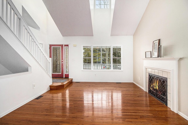 unfurnished living room with hardwood / wood-style floors and a tile fireplace