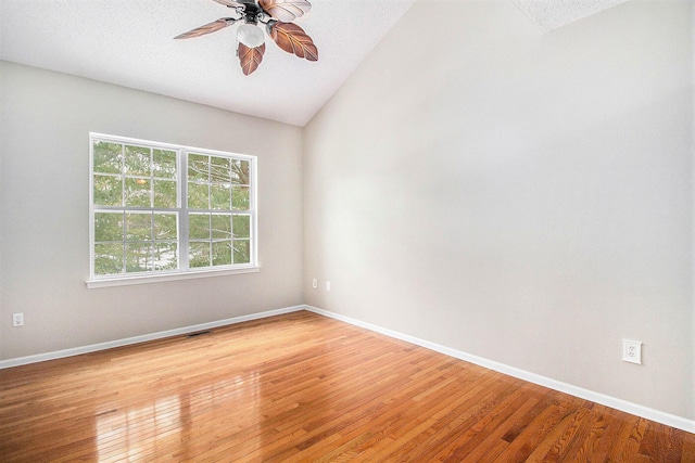 unfurnished room featuring ceiling fan, vaulted ceiling, a textured ceiling, and light hardwood / wood-style flooring